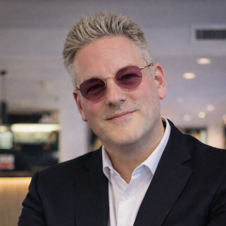 Porträt von Peter Zimmermann mit freundlichem Lächeln, in Anzugjacke.